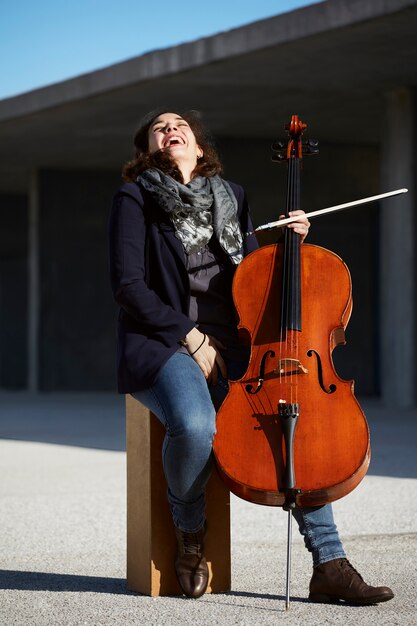 彼女の楽器に満足して笑っている若い女性