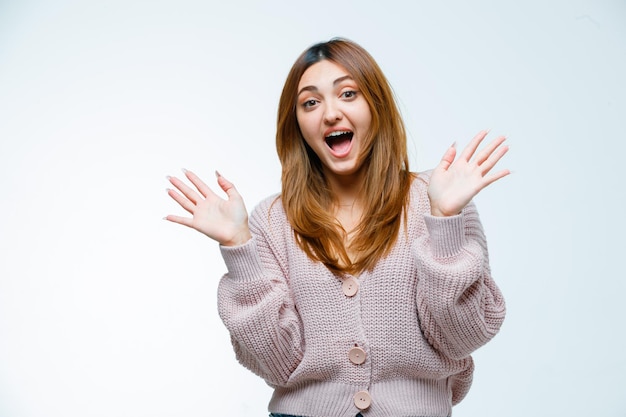 Young woman laughing while raising hands up