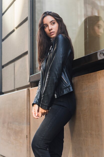 Young woman leaning against wall