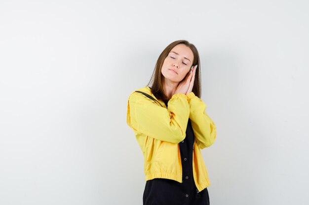 Young woman leaning cheek on palms and looking sleepy