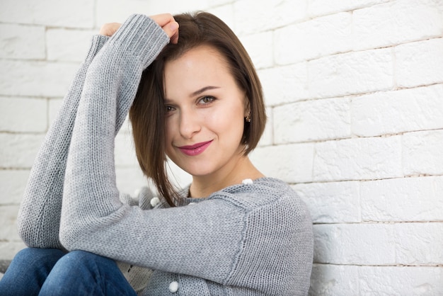 Free photo young woman leaning on wall