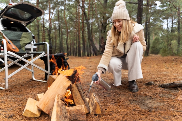 Young woman lighting the fire with torch during camp