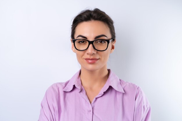 Young woman in a lilac shirt on a white background in glasses for vision cheerful positive in a good mood