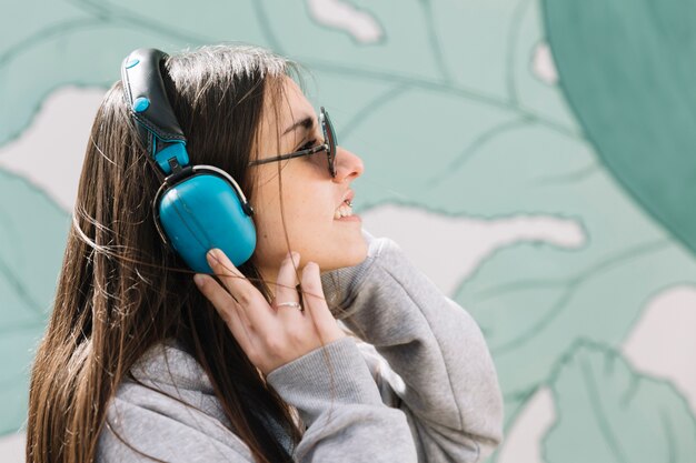 Young woman listening music on blue headphones