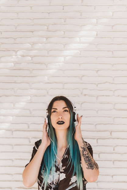 Free photo young woman listening music on headphone