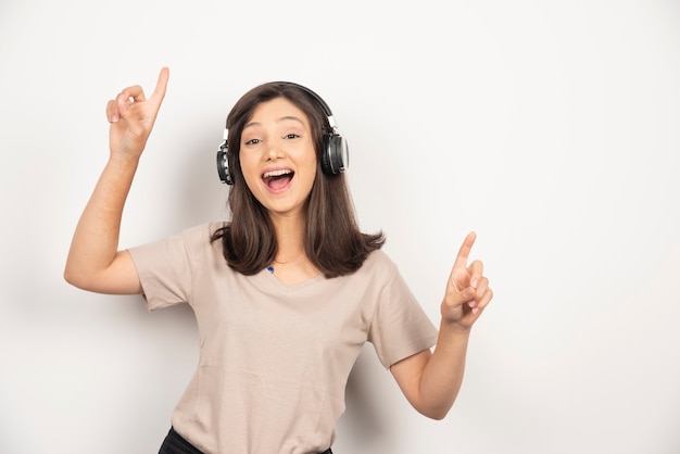 Young woman listening music in headphones and dancing.