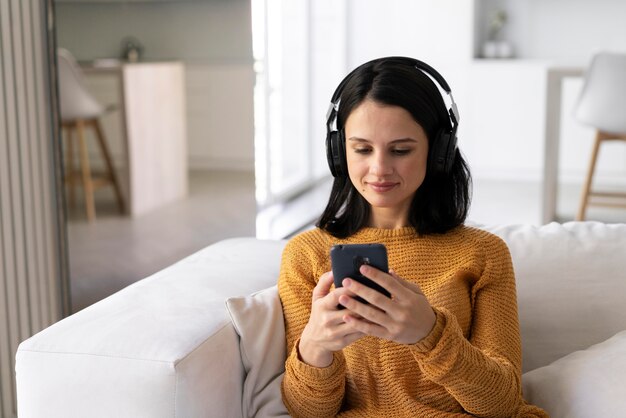 Молодая женщина, слушающая музыку дома