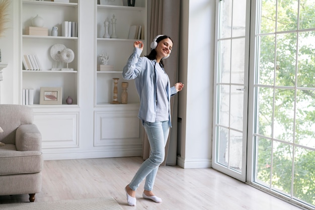 Free photo young woman listening to music at home