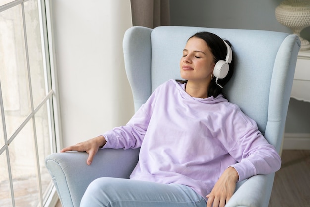 Молодая женщина, слушающая музыку дома