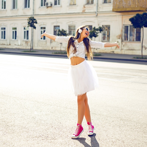 Free photo young woman listening to music at the street