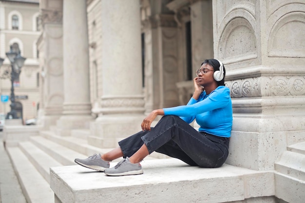 young woman listens to music in the city