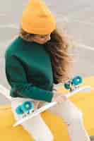 Бесплатное фото Молодая женщина, глядя на колеса скейтборда