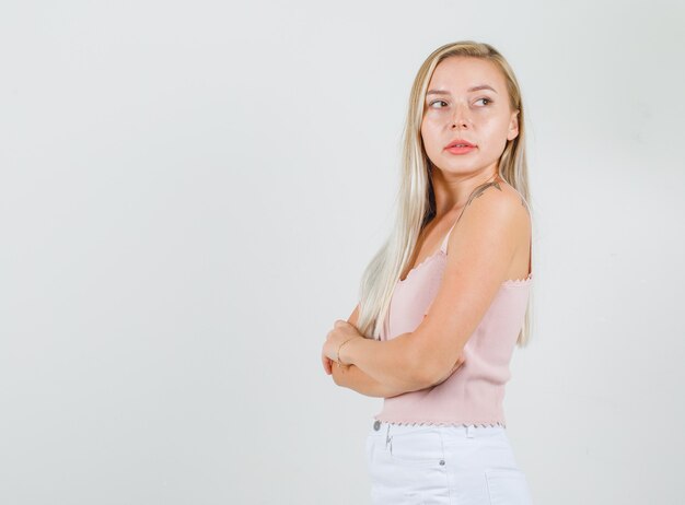 Young woman looking back over her shoulder in singlet, mini skirt and looking confident