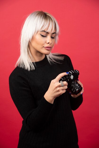 Young woman looking on a camera on a red background. High quality photo