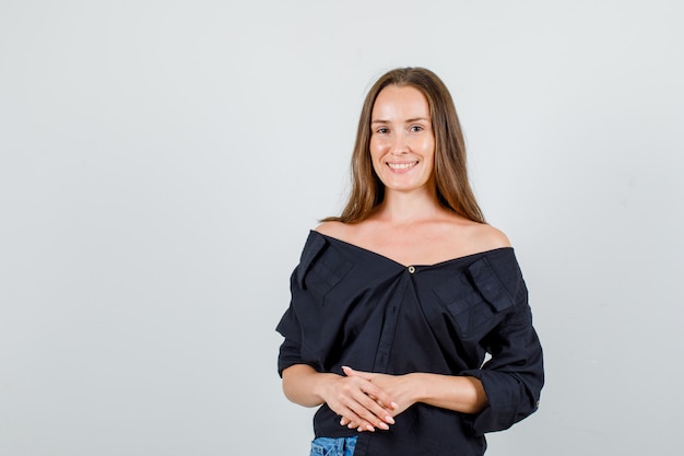 Free photo young woman looking at camera in shirt, shorts and looking cheerful