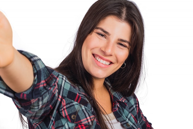 Giovane donna che guarda la fotocamera e prendendo un selfie.