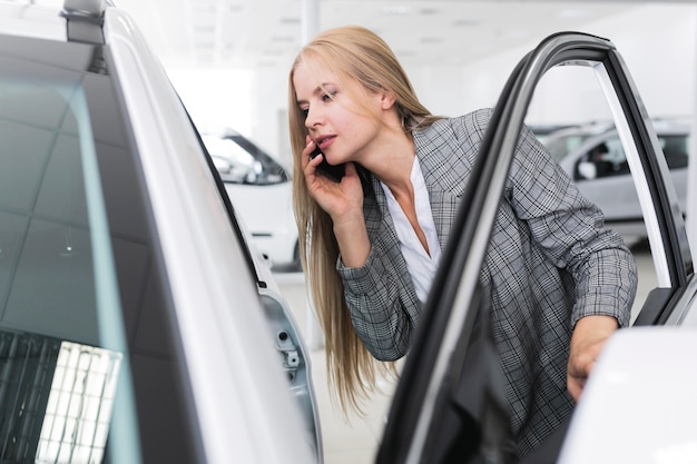 車のミディアムショットで探している若い女性