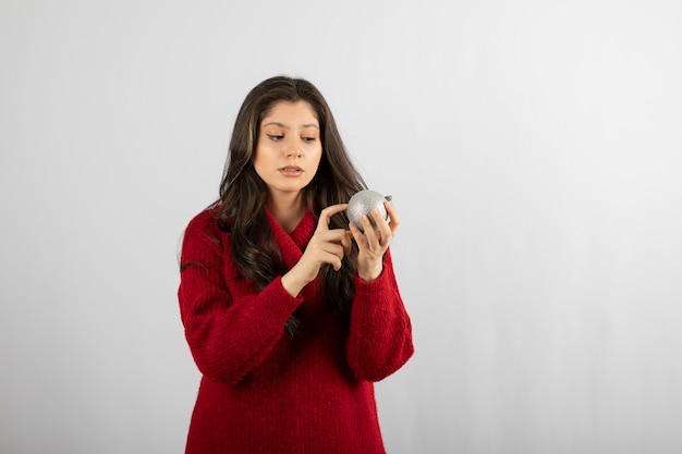 A young woman looking at a Christmas bauble .