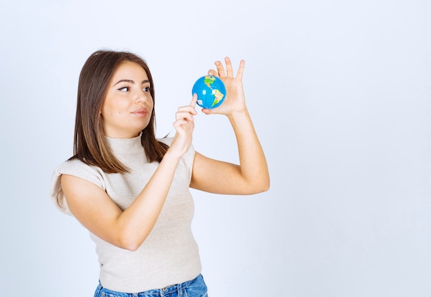 Young woman looking at an Earth globe ball