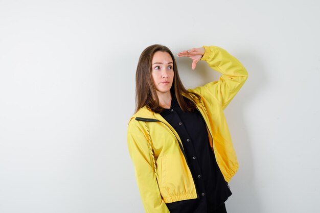 Young woman looking far away with hand over head