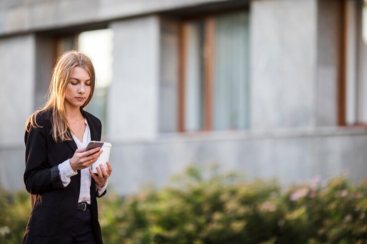 Free Photo young woman looking at phone mid shot