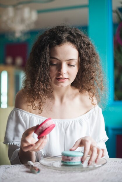 Giovane donna che esamina il panino gelato rosa e blu sulla lastra di vetro