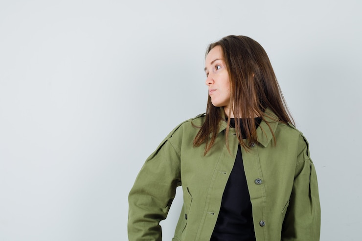 Free Photo young woman looking at right side in green jacket front view.