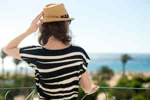 Free photo young woman looking at sea from balcony