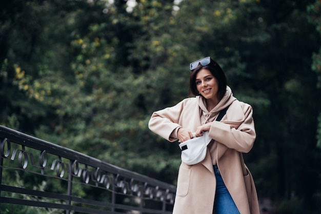 Free photo young woman looking for something in her purse during walk