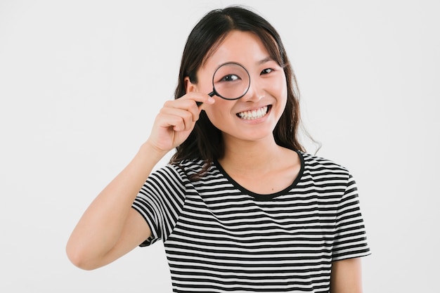 Young woman looking through magnifier