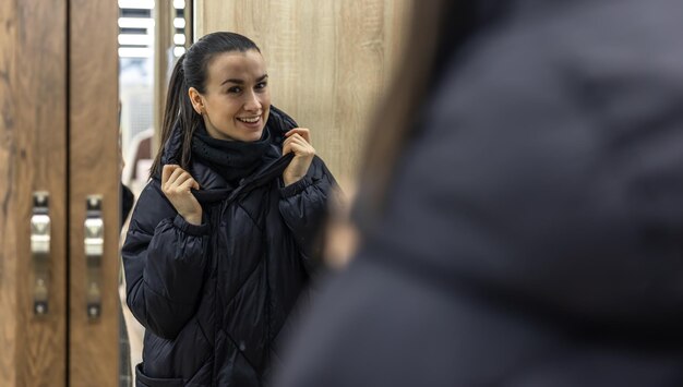 A young woman looks at herself in a closet mirror