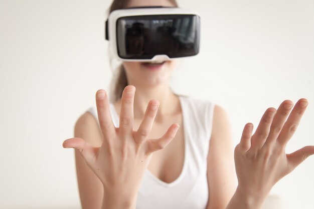 VR 안경을 통해 자신의 손에 보이는 젊은 여자