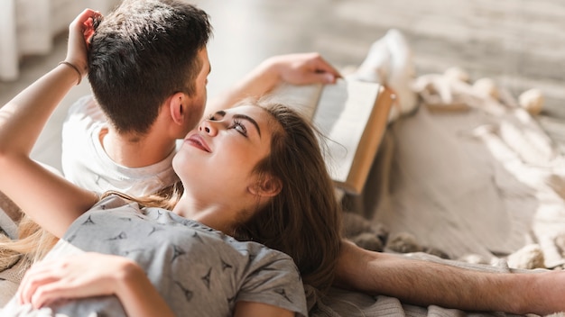 Young woman loving her boyfriend reading book