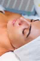 Free photo young woman lying on cosmetologist's table during rejuvenation procedure.
