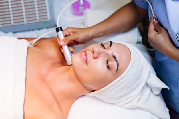 Young woman lying on cosmetologist's table during rejuvenation procedure