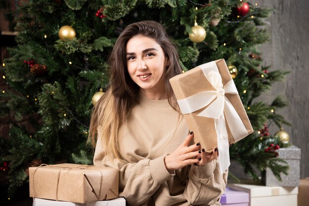 クリスマスプレゼントとふわふわのカーペットの上に横たわっている若い女性。