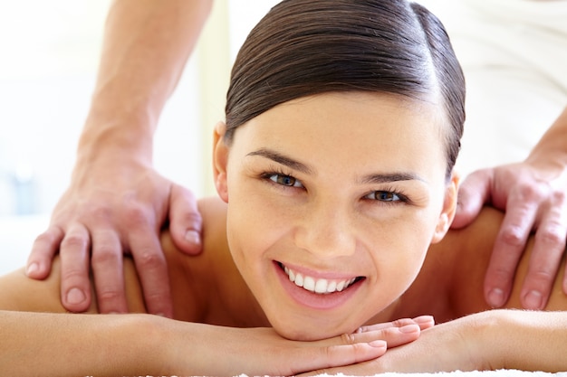 Young woman lying down on a massage bed