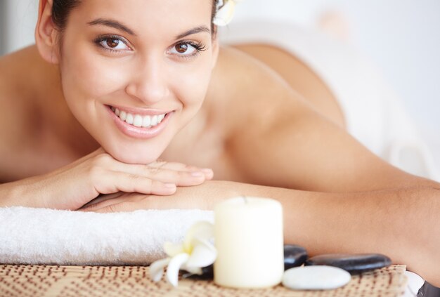 Young woman lying on the massage table and smiling