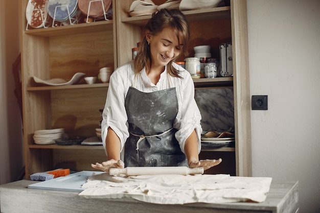 Young woman makes pottery in workshop