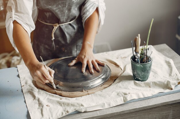 Young woman makes pottery in workshop