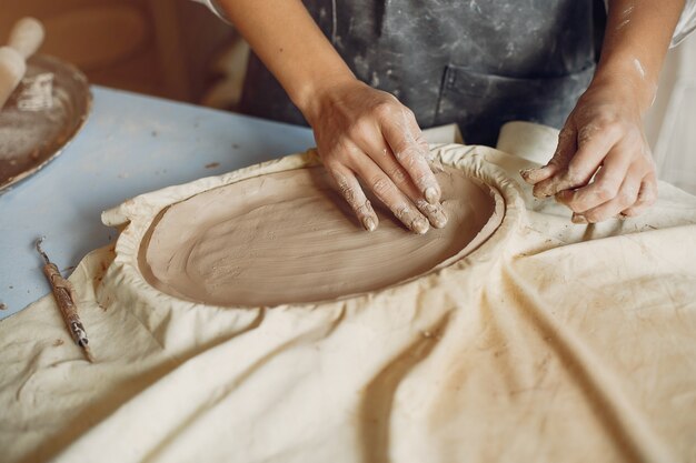 Young woman makes pottery in workshop