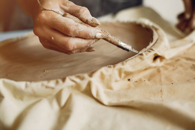 Young woman makes pottery in workshop