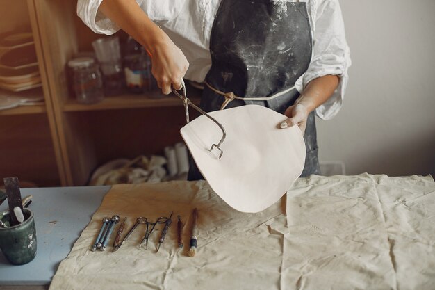 若い女性はワークショップで陶器を作る