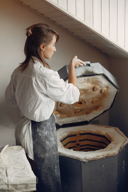 Young woman makes pottery in workshop