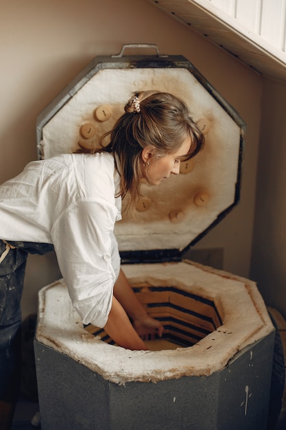 Free photo young woman makes pottery in workshop