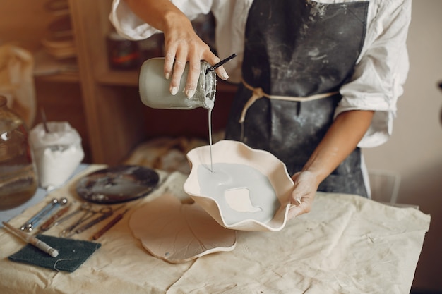 若い女性はワークショップで陶器を作る