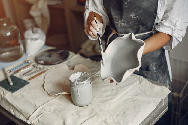 Young woman makes pottery in workshop