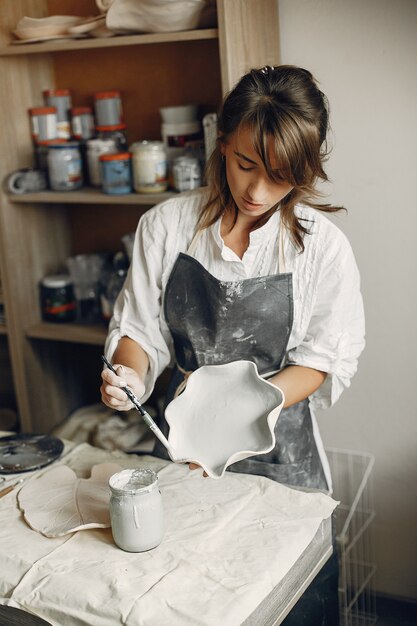 Young woman makes pottery in workshop