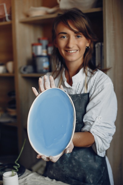 Young woman makes pottery in workshop