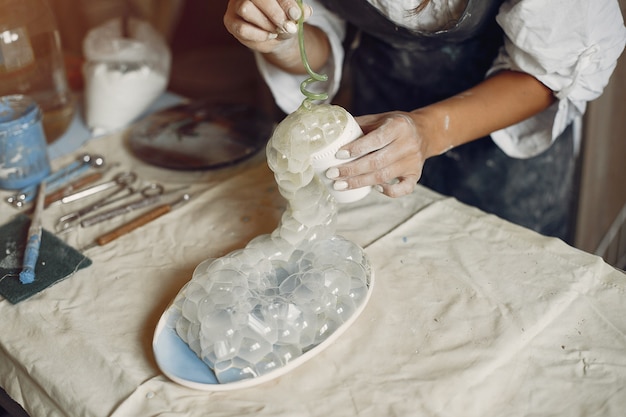 Young woman makes pottery in workshop